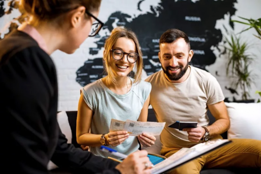 couple booking flights with travel agent
